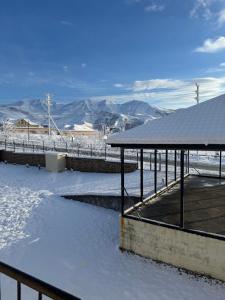 a snow covered field with a pavilion and mountains at house for daily rent in Laza