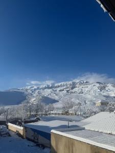 a snow covered roof of a house with mountains in the background at house for daily rent in Laza