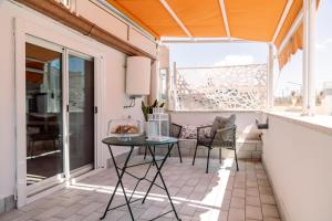 a patio with a table and chairs on a balcony at Il borgo di Ulisse in Gaeta