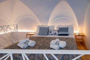 a bed in a room with white walls and pillows at Il borgo di Ulisse in Gaeta