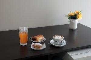 a table with a glass of orange juice and a cup of coffee at Green Wave in Monopoli +15 photos