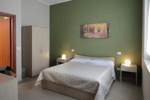 a bedroom with a bed and two lights on two tables at Green Wave in Monopoli