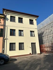 a white building with windows and a car parked in front at Ugo Bassi 98 in Cento