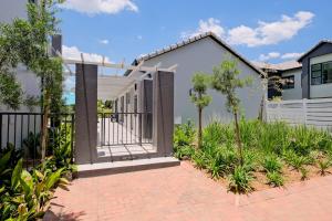 a house with a fence and a brick driveway at The Gentle Abode in Sandton