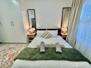 a bedroom with a bed with two towels on it at The Gentle Abode in Sandton +26 photos