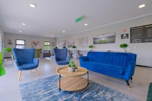 a waiting room with blue chairs and a blue couch at The Gentle Abode in Sandton