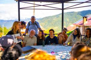 a group of people sitting around a table at Guest House Mokvare in Gundauri