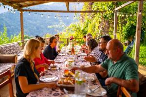 a group of people sitting at a long table eating at Guest House Mokvare in Gundauri