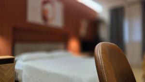 a wooden chair sitting in front of a bed at Centro & Mare - Rooms - Garage - Suites in Termoli +98 photos