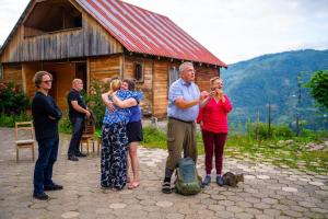 a group of people standing in front of a cabin at Guest House Mokvare in Gundauri