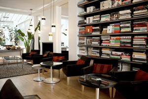 a living room with a large book shelf filled with books at Hôtel Le A - Champs-Elysées in Paris