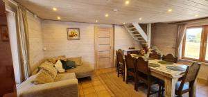 a dining room with a table and a couch at Asvejos sodyba in Skirlėnai