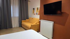 a living room with a couch and a tv on a wall at Centro & Mare - Rooms - Garage - Suites in Termoli
