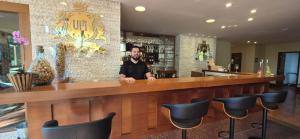 a man standing behind a bar in a restaurant at Cond VISTA AZUL in Pedra Azul +12 photos