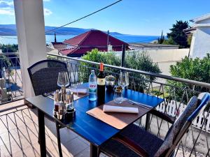 a table with wine bottles and glasses on a balcony at Rooms & Pansion Odmor in Rovanjska