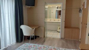 a bedroom with a bed and a table and a mirror at Kamerverhuur Bascule in Roeselare