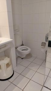 a white bathroom with a toilet and a sink at Kamerverhuur Bascule in Roeselare