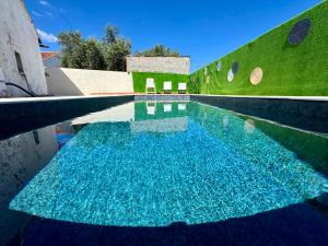 a pool of blue water in front of a building at Casa Alma Serena in Batalha