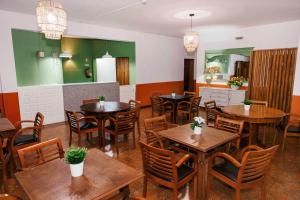 a restaurant with wooden tables and chairs and green walls at Residencial San Fernando in Ponte da Barca