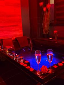 a bar with two glasses of wine and roses at Maison 3 chambres, jacuzzi, billard, sauna, air soccer, clim in Verviers +68 photos