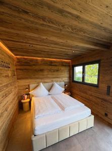a bedroom with a white bed in a wooden wall at Friesensee Camping und Ferienpark in Wittmund