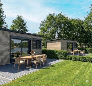 a tiny house with a table and chairs in the yard at Friesensee Camping und Ferienpark in Wittmund