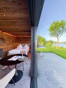 a bedroom with a bed and a table and a view at Friesensee Camping und Ferienpark in Wittmund +52 photos