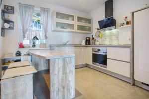 a kitchen with white cabinets and a wooden island at Rügenblick in Klausdorf Mecklenburg Vorpommern