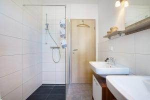 a white bathroom with a shower and a sink at Rügenblick in Klausdorf Mecklenburg Vorpommern +32 photos