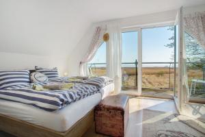 a bedroom with a bed and a large window at Rügenblick in Klausdorf Mecklenburg Vorpommern
