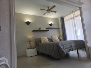 a bedroom with a bed and a ceiling fan at Apartamento en Mar Blau Calella in Calella +29 photos