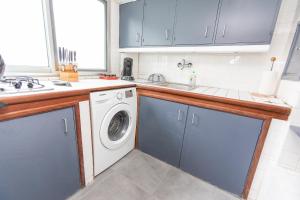 a kitchen with a washing machine and a sink at Appartement T2 atypique de standing in Pointe-Noire