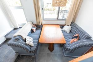 a living room with two couches and a wooden table at Appartement T2 atypique de standing in Pointe-Noire