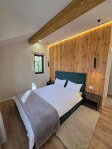 a bedroom with a large bed with a wooden wall at CabanaFriendly in Râşnov