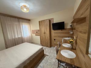 a bedroom with a bed and a table and a tv at Eleonor Guest House in Byala