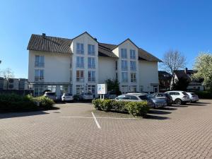 a large building with cars parked in a parking lot at pepb Schulungshotel in Sarstedt