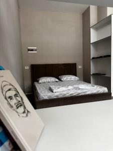 a small bedroom with a bed and a book shelf at Forum View 2 in Durrës