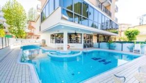 a large swimming pool in front of a building at Depandance President in Cesenatico