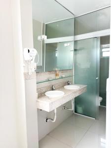 a bathroom with two sinks and a mirror at Hotel Geranius Ingleses in Florianópolis +18 photos
