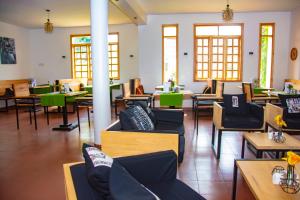 a restaurant with chairs and tables and windows at Coffee Pot Hotel in Kisoro