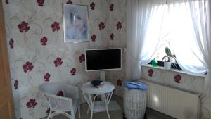 a living room with a tv and a table and chairs at Haus Göhrenz in Markranstädt