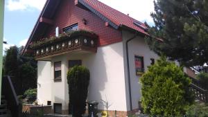 a white and red house with a balcony at Haus Göhrenz in Markranstädt