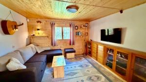 a living room with a couch and a tv at Chata Sekule in Sekule