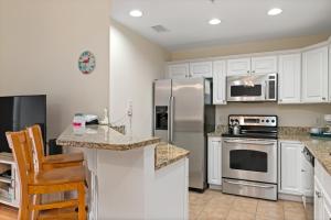 a kitchen with white cabinets and stainless steel appliances at Dreamer by Oak Island Accommodations in Oak Island