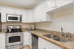 a kitchen with white cabinets and a sink at Dreamer by Oak Island Accommodations in Oak Island +21 photos