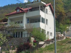 a white house on a hill with stairs at Boračko Lake View Apartment "doelend" in Konjic