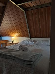 a bedroom with a bed with a wooden wall at #1 Jardín de las cabanas in San Pedro Carchá