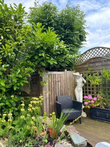 a garden with a chair and a fence and flowers at Silverleigh Spa LTD in Fawkham