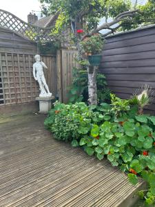 a statue in a garden with a bunch of plants at Silverleigh Spa LTD in Fawkham