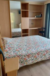 a bedroom with a bed with a floral bedspread at Kamerverhuur Bascule in Roeselare